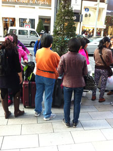 銀座の路上でスーツケース片手にショッピングを楽しむ中国人観光客